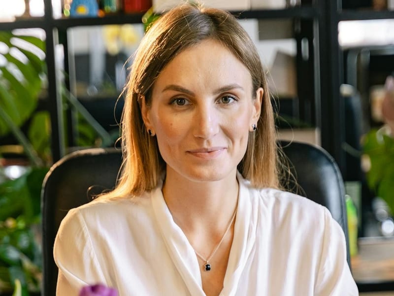 Small-business owner at a desk in a plant-filled office